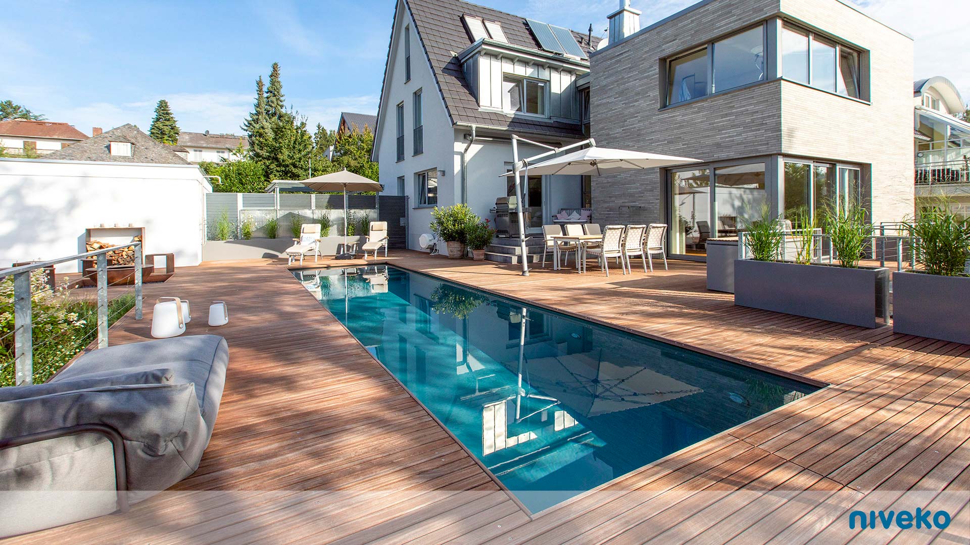 Moderner Hinterhof mit Pool, Holzterrasse, Gartenmöbeln und stilvoller Bepflanzung
