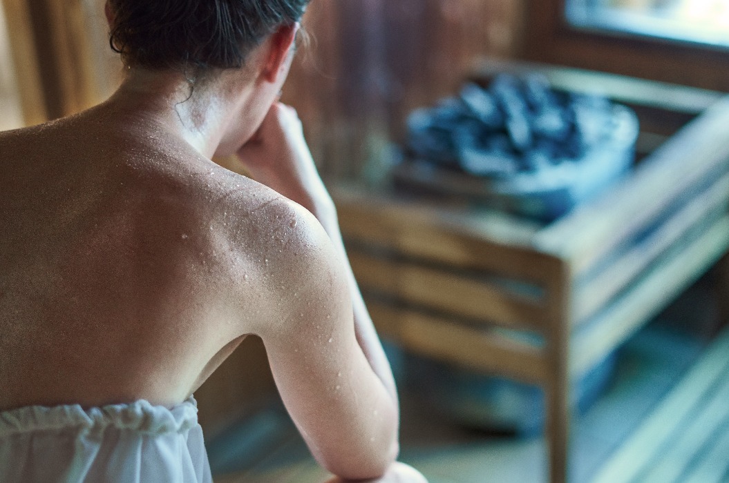 Eine Frau, die in der Sauna schwitzt