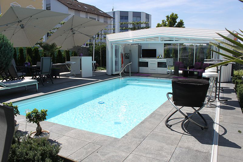 Moderner Swimmingpool im Garten mit weißen Sonnenschirmen und gemütlicher Sitzecke