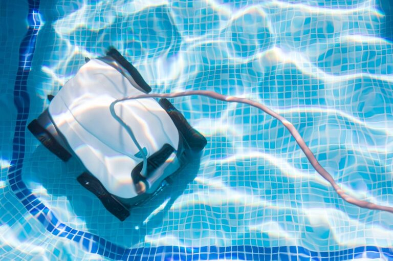 Poolreinigungsroboter – Poolpflege mit automatischem Roboter. Reinigung des Poolbodens und der Wände mit einem Unterwasserroboter. Poolreinigungsroboter im Sommer vor dem Baden.