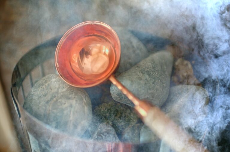 Saunasteine / heiße Steine für die Wasserversorgung, Dampf auf den Steinen in der Sauna, Spa-Konzept, Entspannung bei Wärme