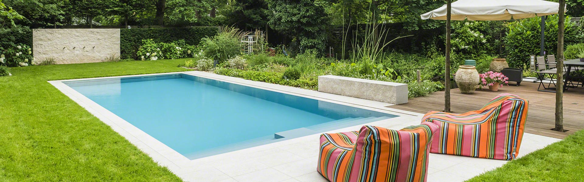 Moderner Garten mit rechteckigem Pool, zwei bunten Sitzsäcken und viel Grün