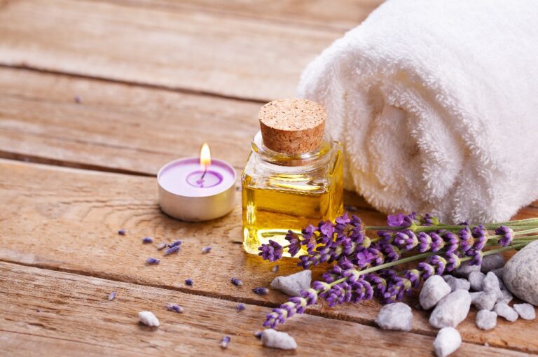 Spa-Stillleben mit Lavendelöl, weißem Handtuch und Duftkerze