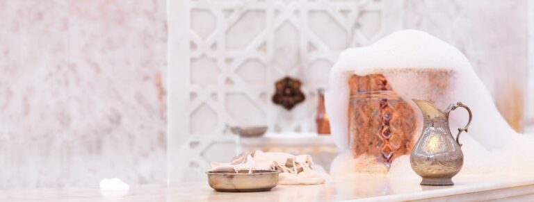 Wasserkrug, Handtuch und Kupferschale mit Seifenschaum in einem türkischen Hamam. Traditionelle Einrichtungsdetails
