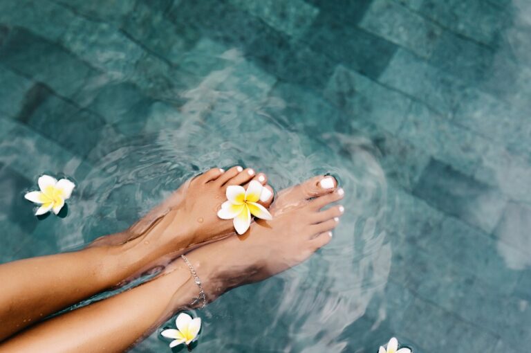 Füße mit Blume am Zeh im Pool