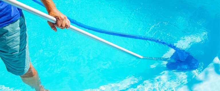 Swimming pool cleaning. a man is cleaning the pool. service care